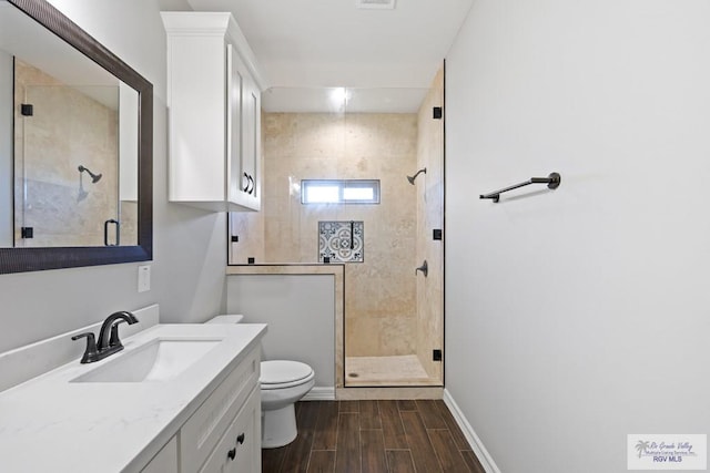 bathroom featuring hardwood / wood-style floors, vanity, toilet, and walk in shower