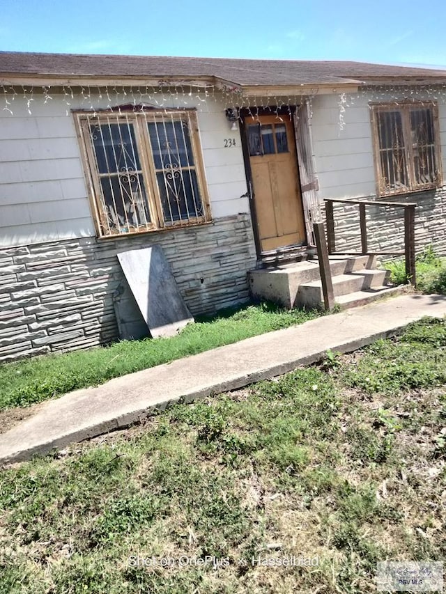 property entrance featuring stone siding