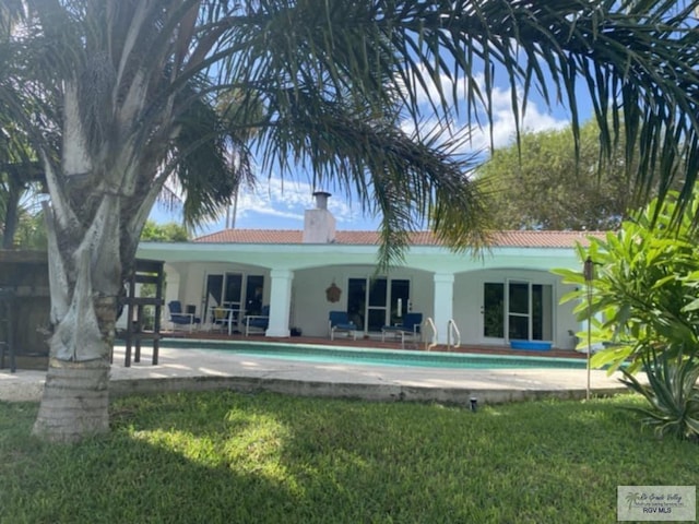 back of property featuring a lawn and a patio