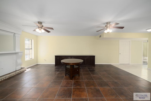 sitting room featuring a ceiling fan, visible vents, dark tile patterned floors, and baseboards