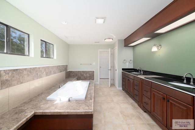 bathroom with double vanity, a sink, a bath, and tile patterned floors