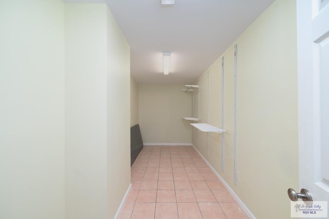 corridor with light tile patterned flooring and baseboards