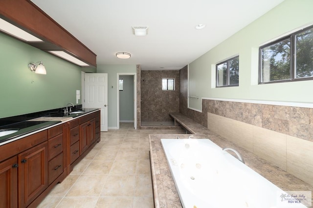 full bath featuring double vanity, a stall shower, baseboards, a tub with jets, and tile patterned floors