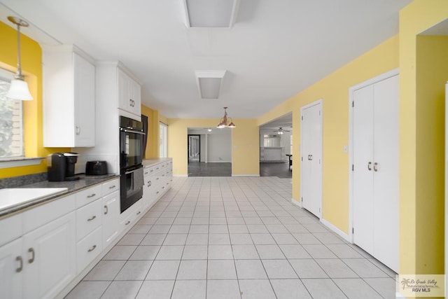 kitchen with light tile patterned floors, pendant lighting, white cabinets, and dobule oven black