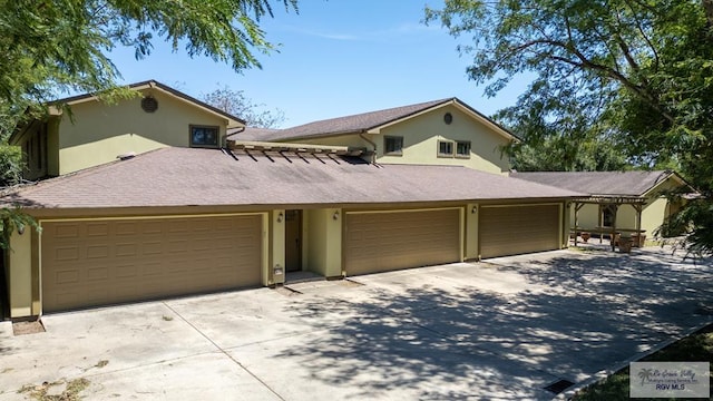 view of front of house with a garage, driveway, and stucco siding