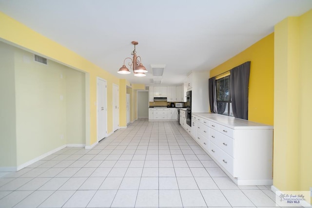 kitchen with pendant lighting, light tile patterned floors, white cabinets, a chandelier, and baseboards