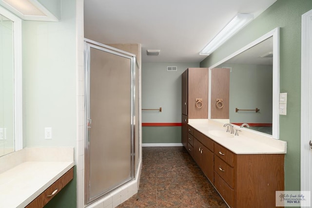 bathroom featuring visible vents, vanity, baseboards, a shower stall, and stone finish flooring