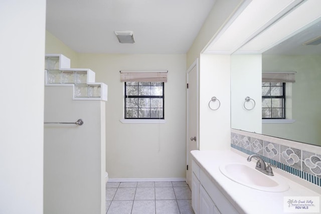 bathroom with tile patterned flooring, baseboards, and vanity