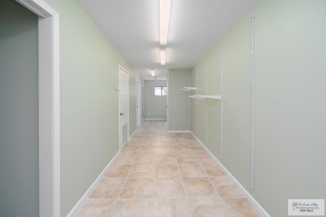 hall with light tile patterned floors and baseboards