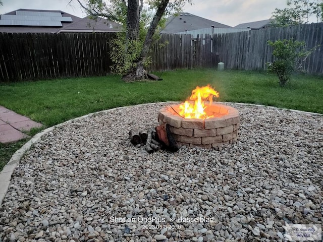 view of yard featuring a fire pit and a fenced backyard