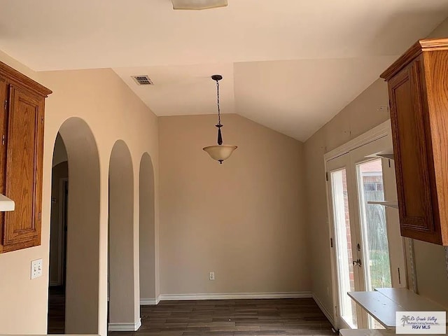 unfurnished dining area with visible vents, baseboards, dark wood-type flooring, and vaulted ceiling