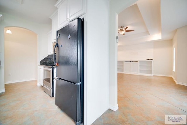 kitchen with white cabinetry, ceiling fan, black fridge, stainless steel range oven, and dark stone countertops