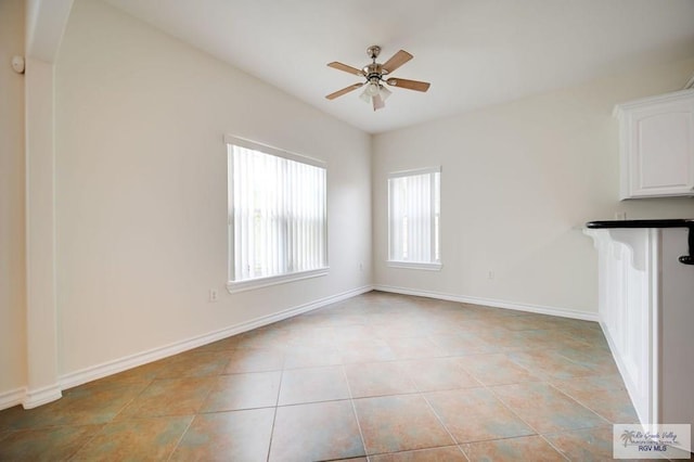 interior space with light tile patterned floors and ceiling fan