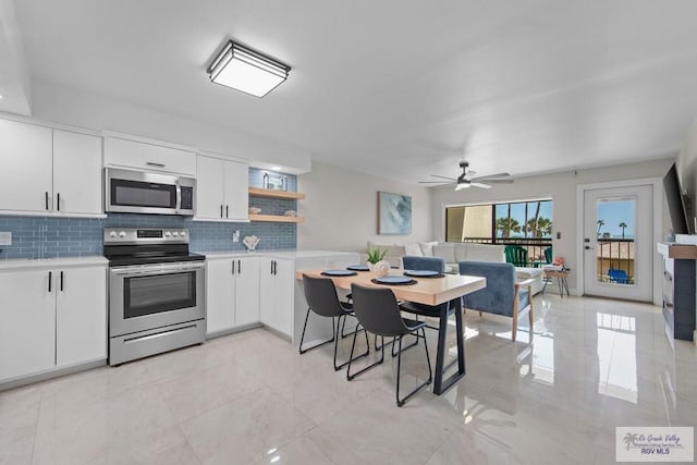 kitchen featuring stainless steel appliances, white cabinets, and decorative backsplash