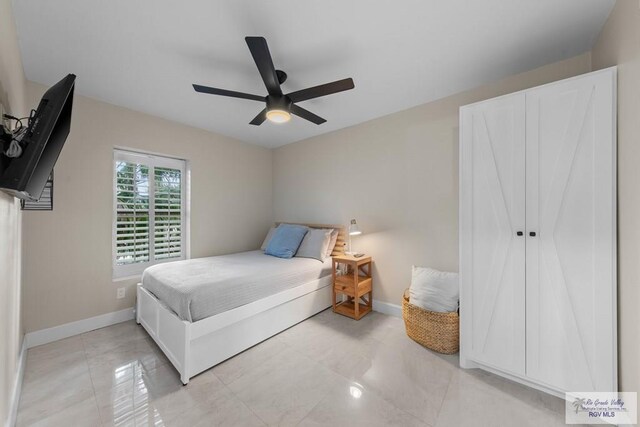 bedroom with ceiling fan and light tile patterned flooring