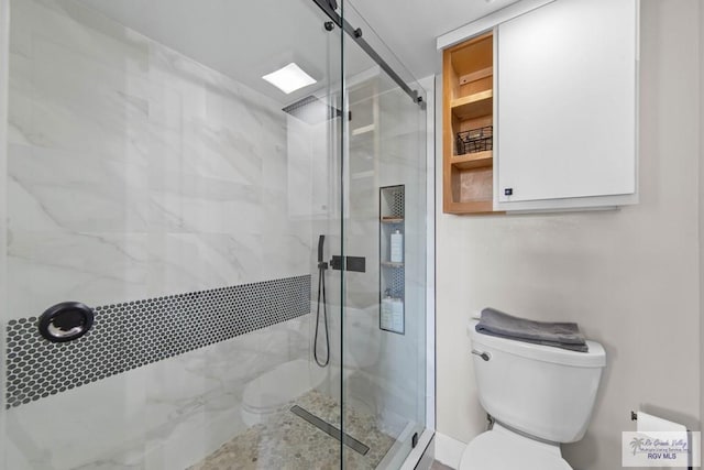 bathroom with a shower with door and toilet