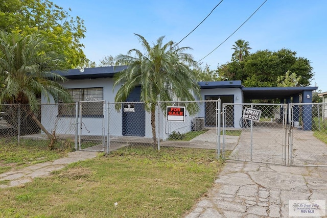 view of front of house featuring a front lawn, cooling unit, and a carport