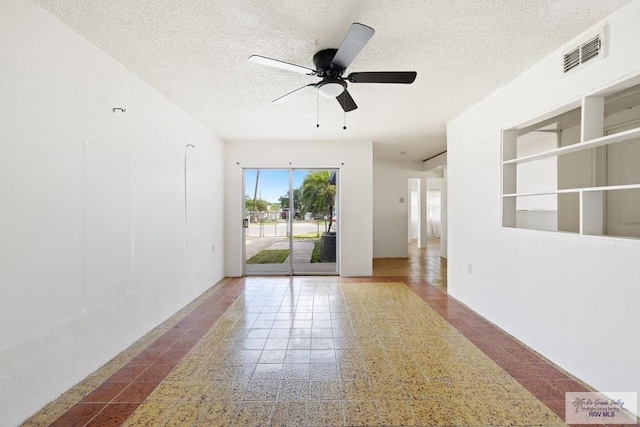 unfurnished room featuring built in shelves, a textured ceiling, and ceiling fan