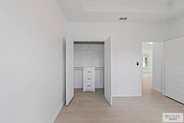 unfurnished bedroom with a closet and light hardwood / wood-style flooring