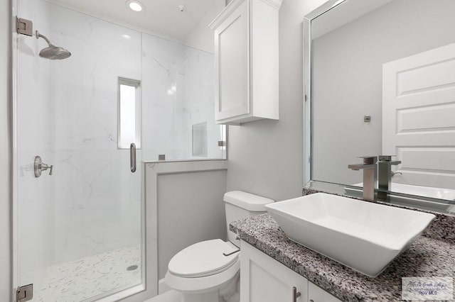 bathroom featuring vanity, toilet, and a shower with shower door