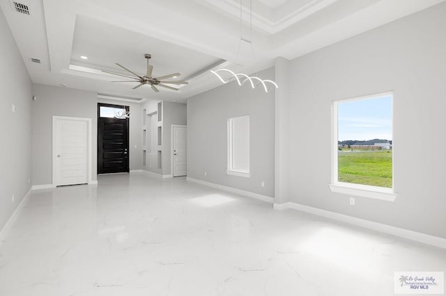 spare room featuring a tray ceiling and ceiling fan