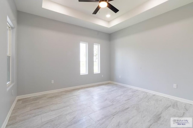 21929 Hand Rd, Harlingen, TX 78552 - empty room featuring ceiling fan, a tray ceiling, and baseboards