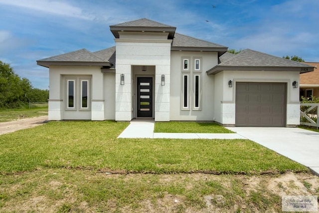 21929 Hand Rd, Harlingen, TX 78552 - prairie-style home featuring an attached garage, a shingled roof, concrete driveway, and a front lawn