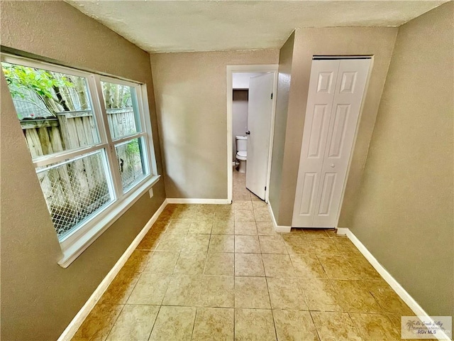 corridor with light tile patterned flooring