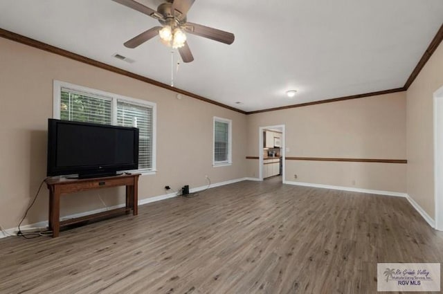 501 Ratliff St, San Benito, TX 78586 - unfurnished living room with wood finished floors, ornamental molding, and a ceiling fan