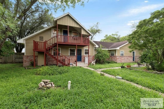 501 Ratliff St, San Benito, TX 78586 - rear view of property featuring stairway, brick siding, and a wooden deck