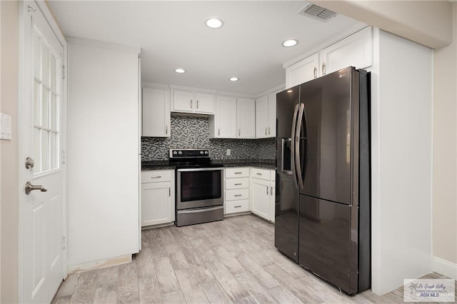 kitchen with white cabinetry, electric range, black fridge, light hardwood / wood-style flooring, and backsplash