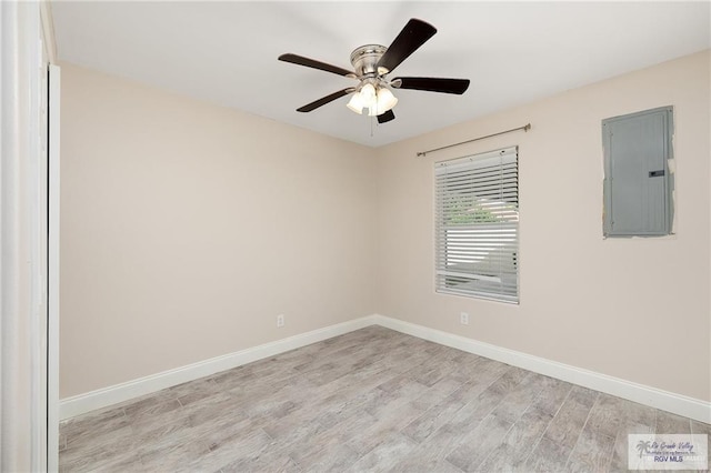 spare room featuring electric panel, ceiling fan, and light hardwood / wood-style floors