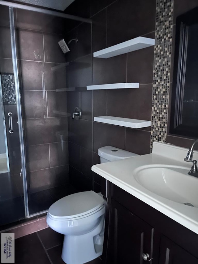 bathroom featuring decorative backsplash, an enclosed shower, vanity, tile patterned flooring, and toilet