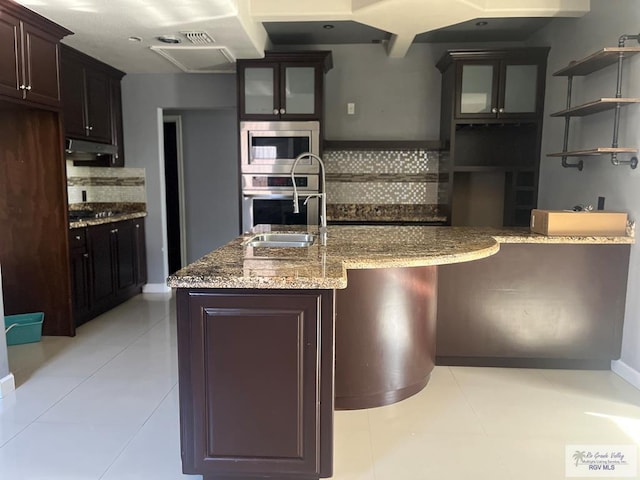 kitchen featuring tasteful backsplash, dark brown cabinets, stainless steel appliances, sink, and light tile patterned floors