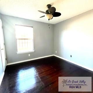 spare room with ceiling fan and dark hardwood / wood-style flooring