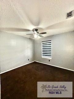 empty room with a textured ceiling and ceiling fan