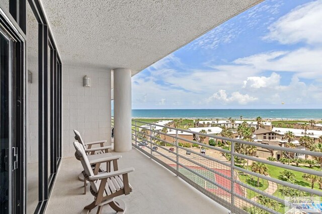 balcony with a water view and a beach view