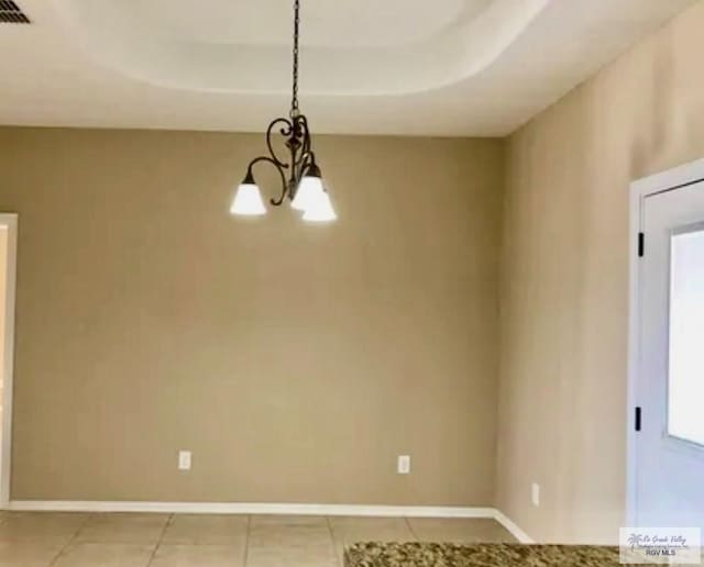 401 S Tamm Ln, Harlingen, TX 78550 - unfurnished room featuring a chandelier, light tile patterned flooring, and a tray ceiling