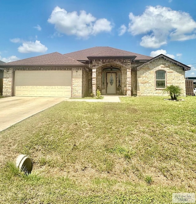 401 S Tamm Ln, Harlingen, TX 78550 - view of front facade with stone siding, an attached garage, concrete driveway, and a front lawn