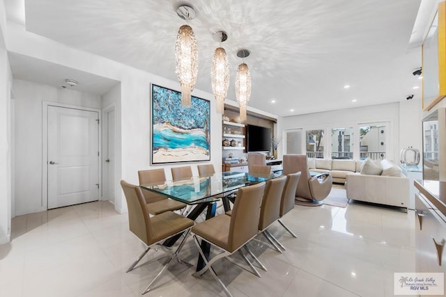 dining room with light tile patterned flooring and a notable chandelier