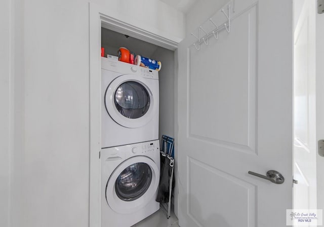 clothes washing area with stacked washer and dryer