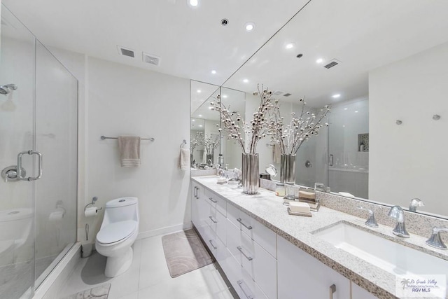 bathroom featuring vanity, a shower with shower door, tile patterned floors, and toilet