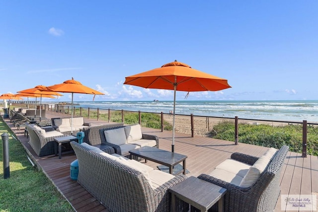 wooden deck featuring a water view, an outdoor hangout area, and a view of the beach