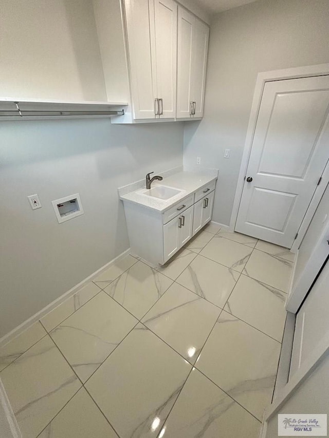 clothes washing area with cabinets, washer hookup, and sink