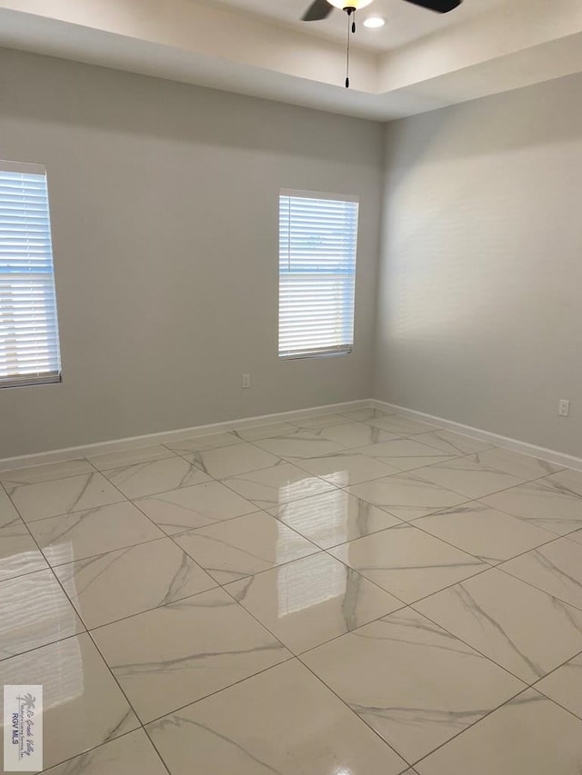 spare room with ceiling fan and a healthy amount of sunlight