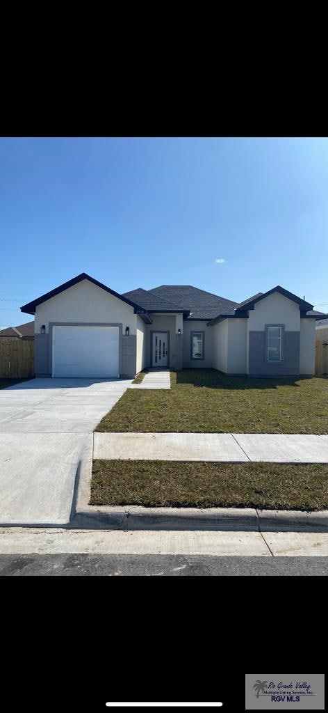 ranch-style home with a garage and a front lawn