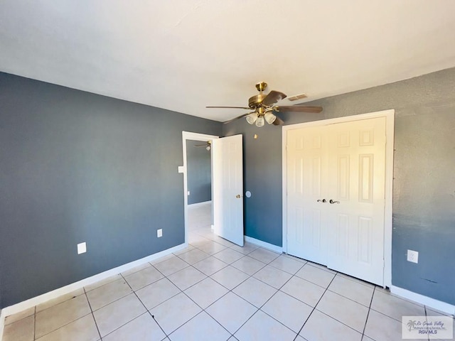 unfurnished bedroom with ceiling fan, light tile patterned floors, and a closet