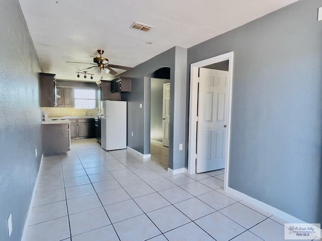 kitchen featuring ceiling fan, white fridge, and light tile patterned flooring