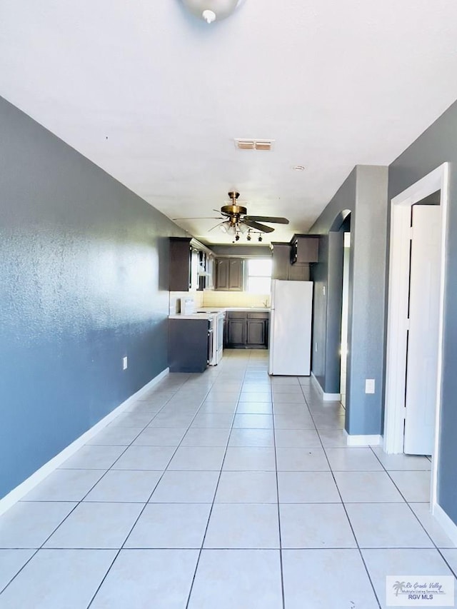 unfurnished living room with light tile patterned floors and ceiling fan