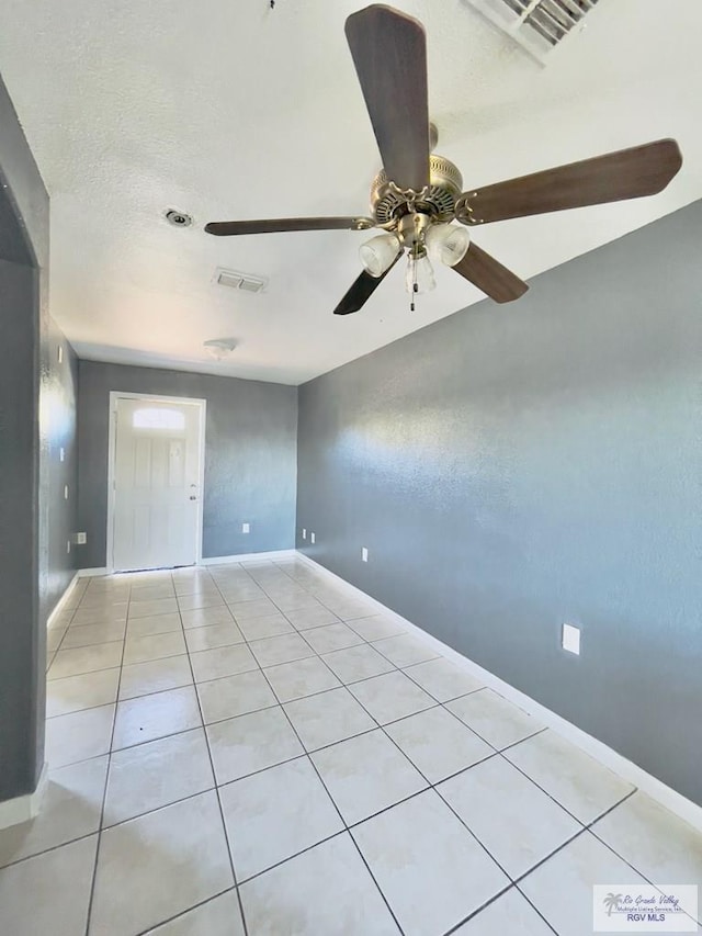 spare room with light tile patterned floors, a textured ceiling, and ceiling fan